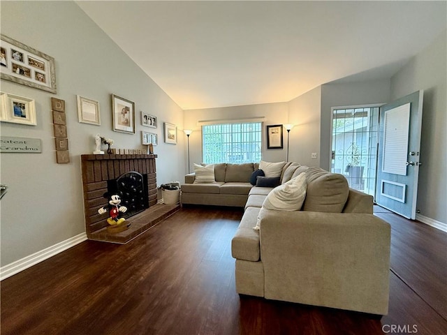 2579 Oak Springs Pl, Ontario, CA 91761 - living room featuring dark wood-type flooring, lofted ceiling, a brick fireplace, and baseboards