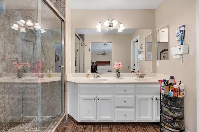 ensuite bathroom with double vanity, a shower stall, and a sink