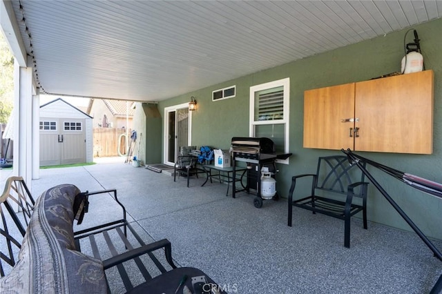 view of patio / terrace with visible vents, an outbuilding, a shed, and fence