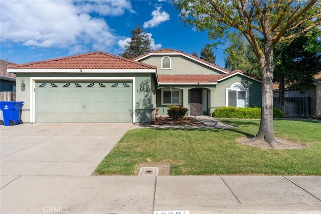 view of front facade featuring fence, a tiled roof, a front lawn, an attached garage, and driveway
