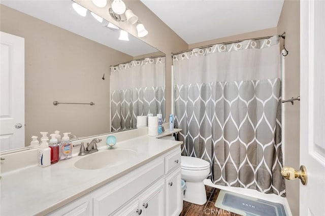 full bath with a shower with curtain, wood finished floors, vanity, and toilet