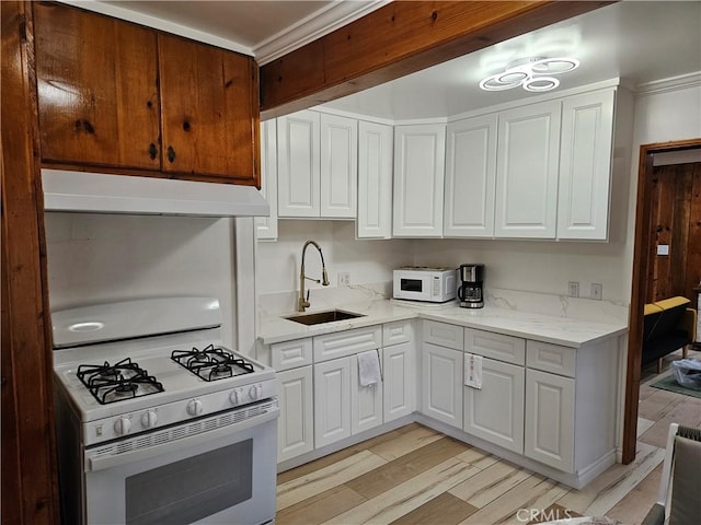 32868 Deer Ln, Running Springs, CA 92382 - kitchen with white appliances, under cabinet range hood, crown molding, white cabinetry, and light wood-style flooring