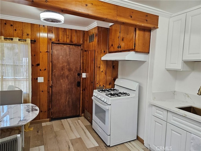 32868 Deer Ln, Running Springs, CA 92382 - kitchen with white gas stove, range hood, light wood-type flooring, white cabinets, and light stone countertops