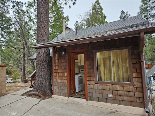 32868 Deer Ln, Running Springs, CA 92382 - property entrance with a chimney and roof with shingles
