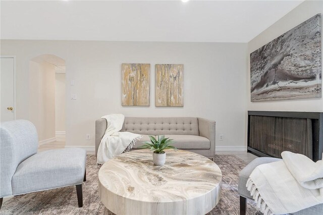 740 N Kings Rd Unit 225, West Hollywood, CA 90069 - living room with arched walkways, baseboards, and a fireplace
