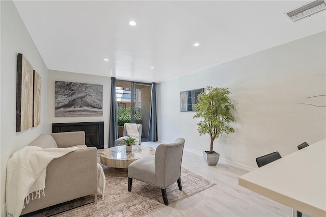 living area featuring recessed lighting, baseboards, visible vents, and wood finished floors