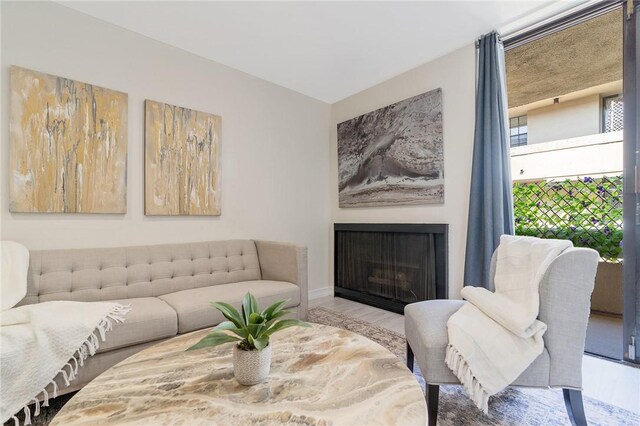 740 N Kings Rd Unit 225, West Hollywood, CA 90069 - living room featuring a fireplace, wood finished floors, and baseboards