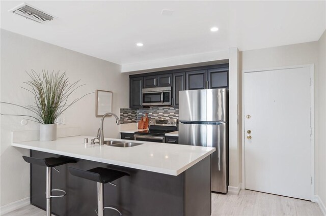 740 N Kings Rd Unit 225, West Hollywood, CA 90069 - kitchen featuring stainless steel appliances, a sink, a kitchen bar, light countertops, and recessed lighting