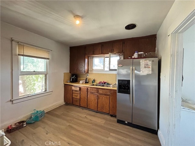 3852 4th St, Riverside, CA 92501 - kitchen with light wood-type flooring, light countertops, brown cabinets, and stainless steel fridge with ice dispenser