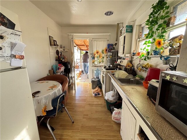 3852 4th St, Riverside, CA 92501 - kitchen with light countertops, light wood-type flooring, visible vents, and white appliances
