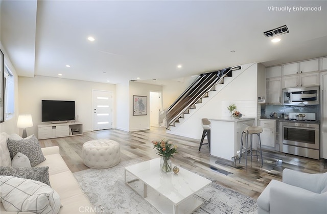 7443 Troost Ave, North Hollywood, CA 91605 - living area featuring recessed lighting, stairway, visible vents, and light wood finished floors