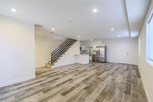 7443 Troost Ave, North Hollywood, CA 91605 - unfurnished living room featuring recessed lighting, light wood-style flooring, visible vents, and baseboards