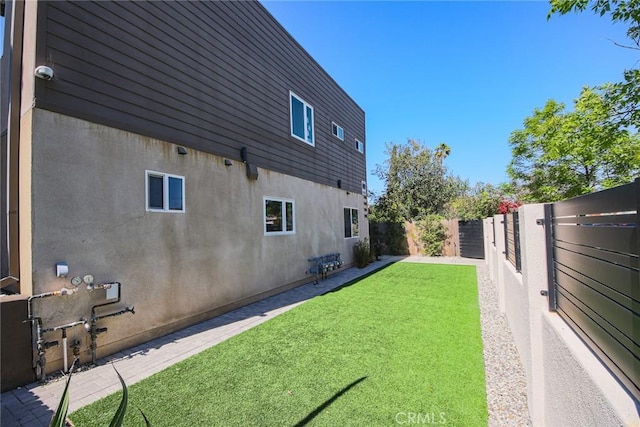 7443 Troost Ave, North Hollywood, CA 91605 - view of home's exterior with a lawn, a fenced backyard, and stucco siding