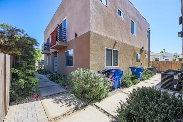 7443 Troost Ave, North Hollywood, CA 91605 - view of property exterior featuring fence, a balcony, central AC, and stucco siding