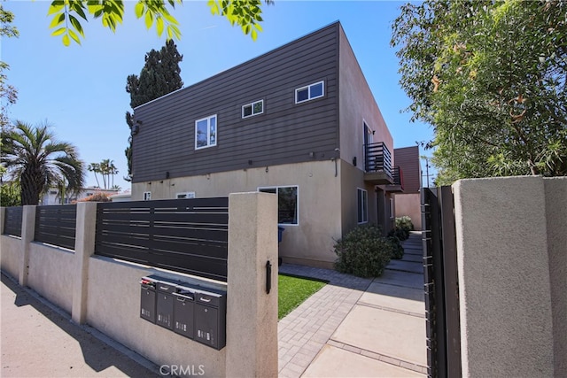 7443 Troost Ave, North Hollywood, CA 91605 - view of home's exterior featuring stucco siding, a gate, and fence