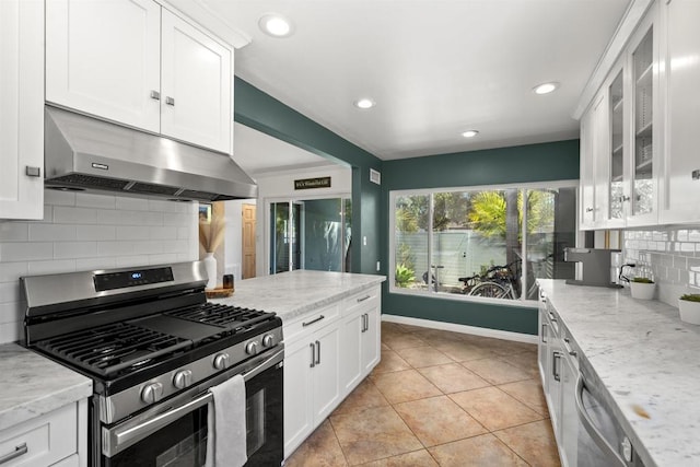 kitchen featuring light tile patterned floors, stainless steel appliances, white cabinets, backsplash, and under cabinet range hood