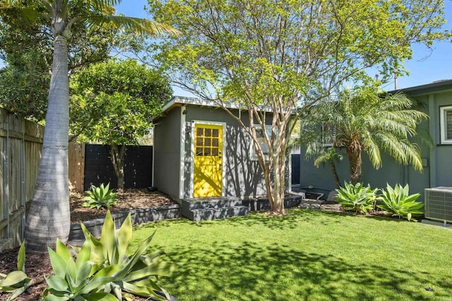view of outdoor structure featuring central air condition unit and fence