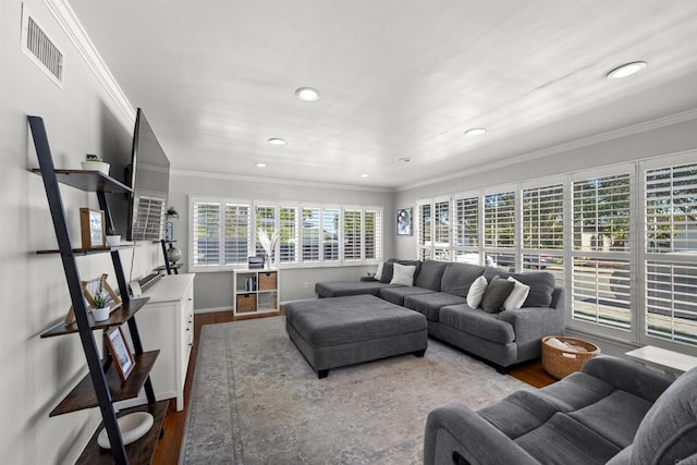 living room with wood finished floors, baseboards, ornamental molding, visible vents, and recessed lighting