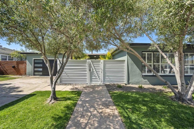 mid-century inspired home with a gate, fence, a front lawn, concrete driveway, and stucco siding