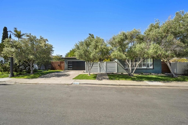 view of front of property with stucco siding, driveway, and fence