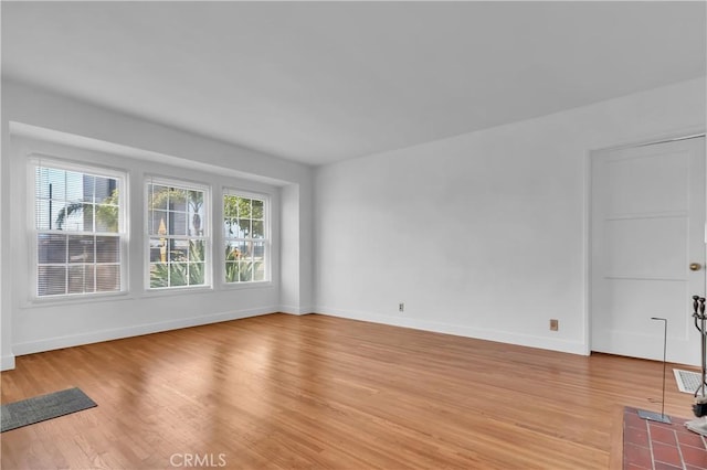 unfurnished room featuring baseboards and light wood-style flooring