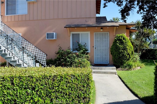 216 S Glenwood Pl, Burbank, CA 91506 - property entrance featuring a lawn, a shingled roof, and an AC wall unit