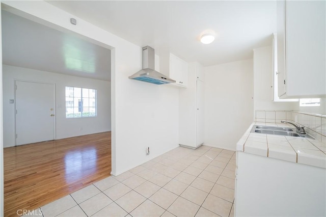 216 S Glenwood Pl, Burbank, CA 91506 - kitchen with a sink, tile counters, white cabinetry, and wall chimney range hood