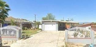 view of front of home with driveway, a garage, fence, and a gate
