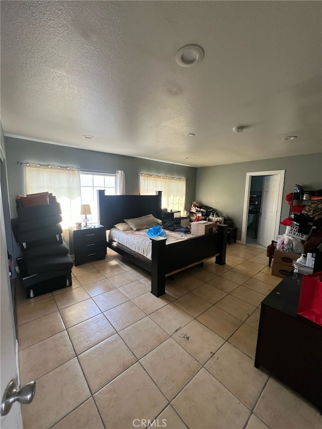 bedroom with light tile patterned flooring and a textured ceiling