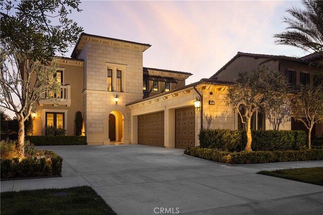 212 Clear Fls, Irvine, CA 92602 - mediterranean / spanish home featuring concrete driveway, stone siding, a balcony, and a garage