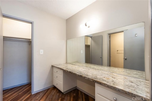 bathroom featuring baseboards, wood finished floors, and vanity
