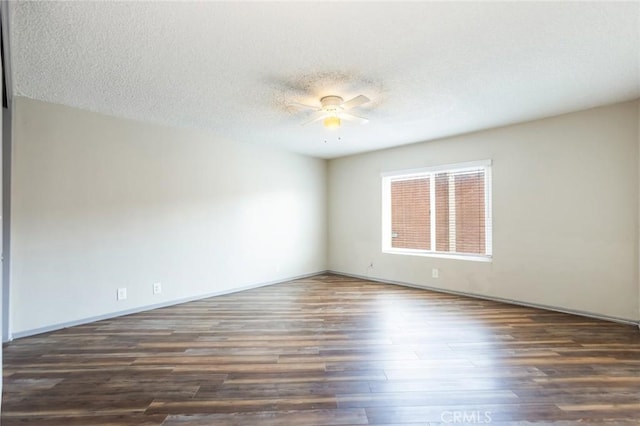 empty room with baseboards, a textured ceiling, ceiling fan, and wood finished floors