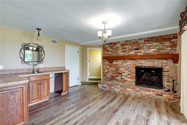 2307 Cameron Ave, Covina, CA 91724 - kitchen with hanging light fixtures, tile countertops, light wood finished floors, and visible vents