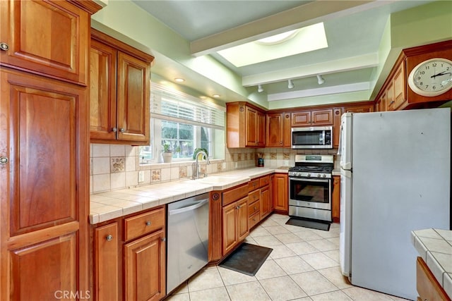 2307 Cameron Ave, Covina, CA 91724 - kitchen with brown cabinets, tasteful backsplash, a sink, light tile patterned floors, and stainless steel appliances