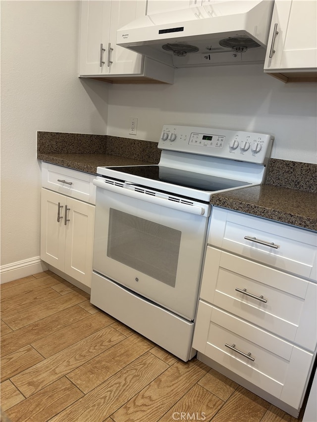 3042 Via Serena S Unit A, Laguna Woods, CA 92637 - kitchen featuring under cabinet range hood, white electric stove, light wood-style flooring, white cabinetry, and baseboards