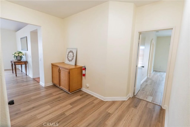 hall featuring baseboards and light wood-type flooring