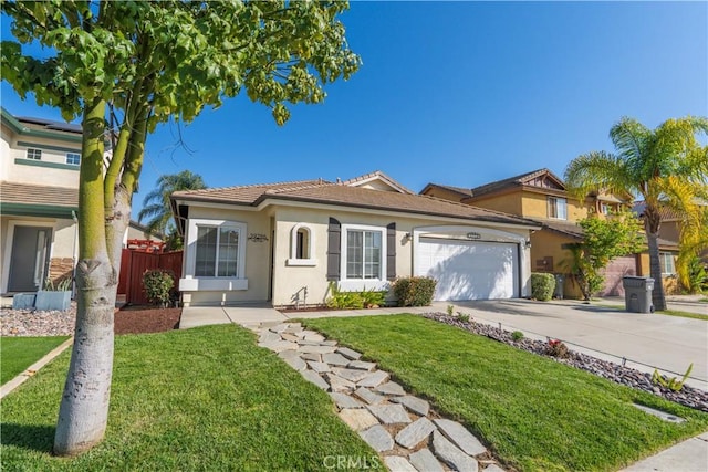 view of front of house featuring an attached garage, driveway, a front lawn, and fence