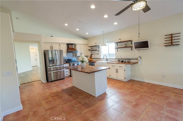 kitchen featuring stainless steel appliances, open shelves, wall chimney exhaust hood, butcher block countertops, and white cabinetry