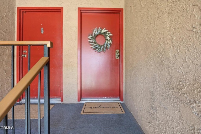 doorway to property featuring stucco siding