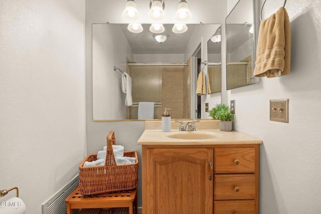 bathroom with visible vents, vanity, and a stall shower