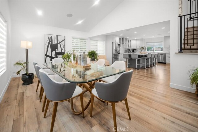 26011 Redbluff Dr, Calabasas, CA 91302 - dining room featuring light wood-style flooring, baseboards, and high vaulted ceiling