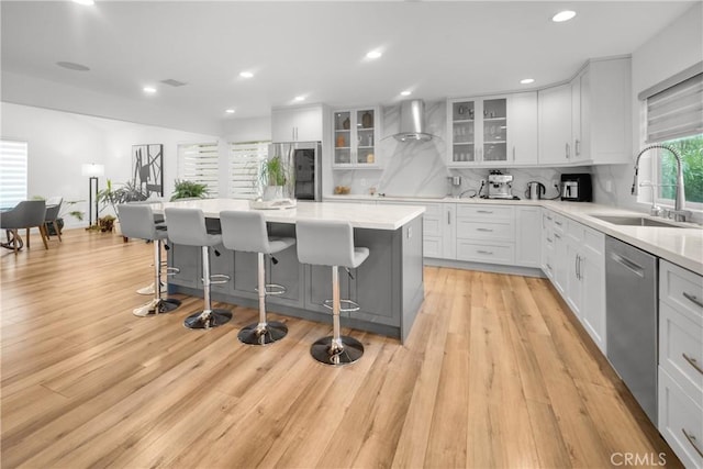 26011 Redbluff Dr, Calabasas, CA 91302 - kitchen with stainless steel dishwasher, a center island, a breakfast bar, a sink, and decorative backsplash
