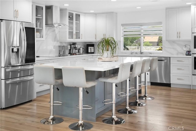 26011 Redbluff Dr, Calabasas, CA 91302 - kitchen featuring stainless steel appliances, backsplash, a kitchen breakfast bar, and wall chimney exhaust hood