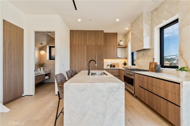 2219 W Starview Ln, Los Angeles, CA 90026 - kitchen with stainless steel stove, a sink, modern cabinets, a kitchen breakfast bar, and light wood finished floors