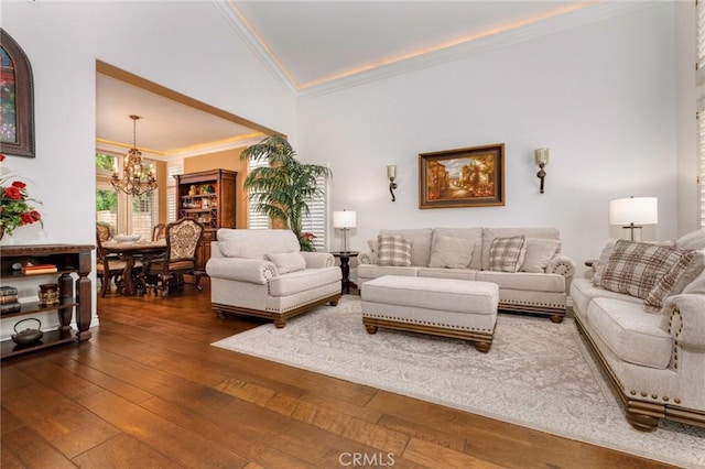 living area with crown molding, a chandelier, and dark wood-type flooring