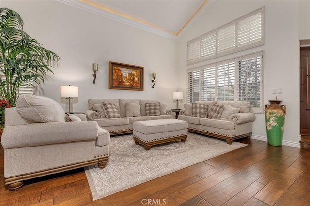 living area with baseboards, high vaulted ceiling, dark wood-type flooring, and crown molding