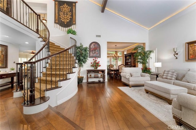 living area with a chandelier, stairway, wood-type flooring, and high vaulted ceiling