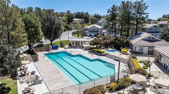 community pool featuring a residential view and fence