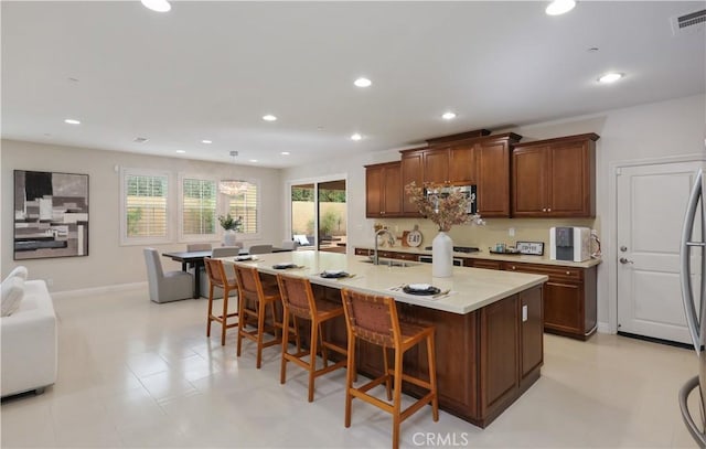 213 Wicker, Irvine, CA 92618 - kitchen with a sink, a kitchen breakfast bar, light countertops, recessed lighting, and a center island with sink