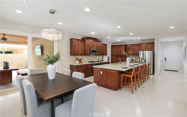 213 Wicker, Irvine, CA 92618 - kitchen featuring stainless steel appliances, a kitchen breakfast bar, light countertops, a center island with sink, and a sink